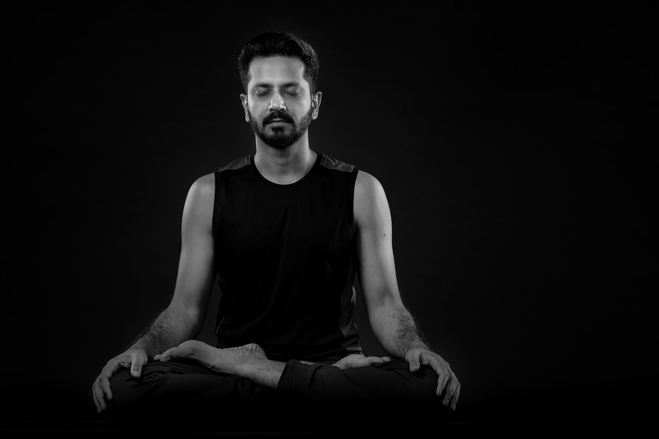 Ankur Bhati seated in meditation against a dark studio background